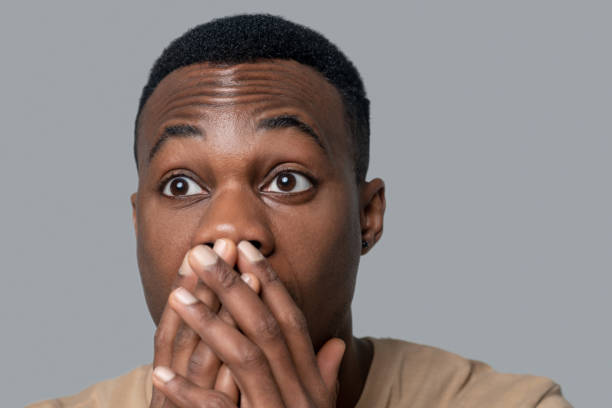istock Dark-skinned young man looking surprised and shocked 1330240380