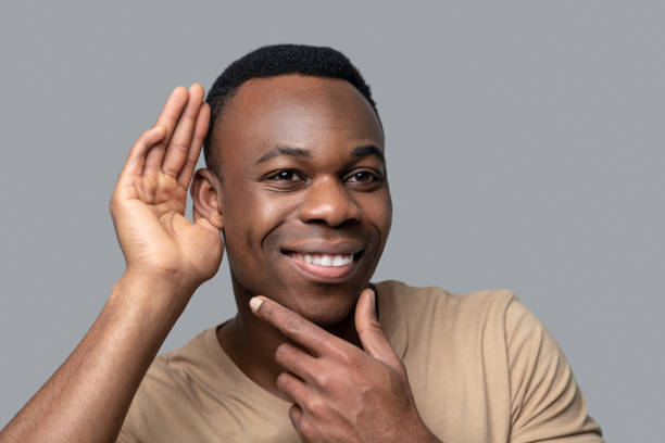 istock Smiling dark-skinned man listening to gossips 1330240419