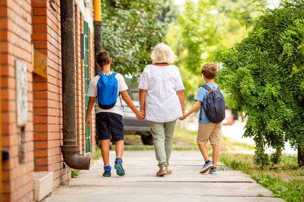 istock Granny is taking boys to school. Rear view. 1330242354