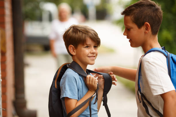 istock Two schoolboys are standing on the street and talking. 1330242416