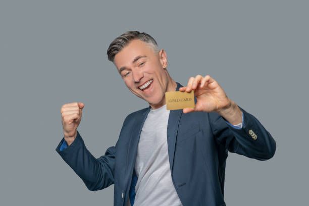 istock Enthusiastic man with gold bank card 1330244890
