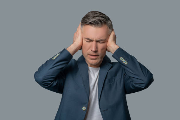 istock Man with drooping eyelids covering ears with hands 1330244899