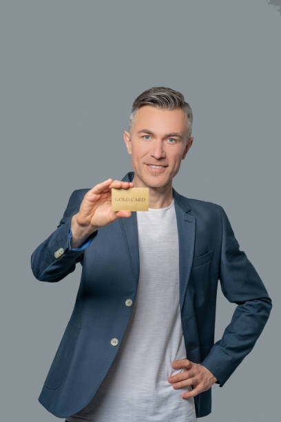 istock Joyful successful man showing bank card 1330244901