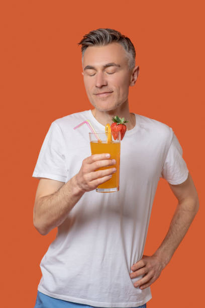 istock Man with closed eyes with glass of fruit cocktail 1330244962