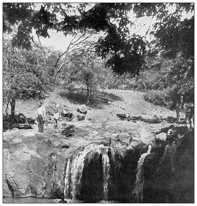 Antique black and white photograph of people from islands in the Caribbean and in the Pacific Ocean; Cuba, Hawaii, Philippines and others: Waterfall near Honolulu, Hawaii