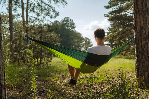 istock Tourist man in a hammock in the forest 1330246095