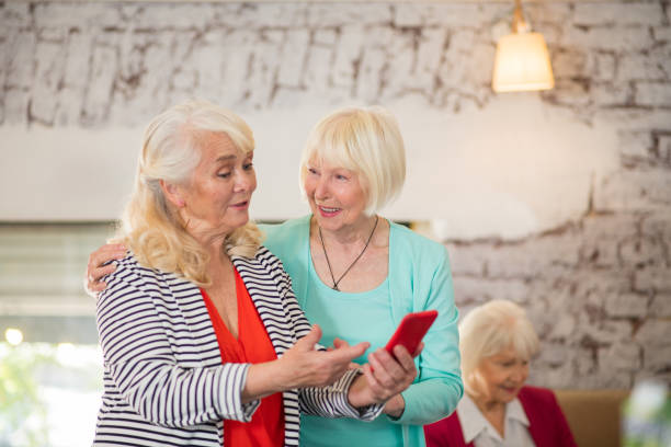 istock Two senior women watching something on a smartphone 1330251577