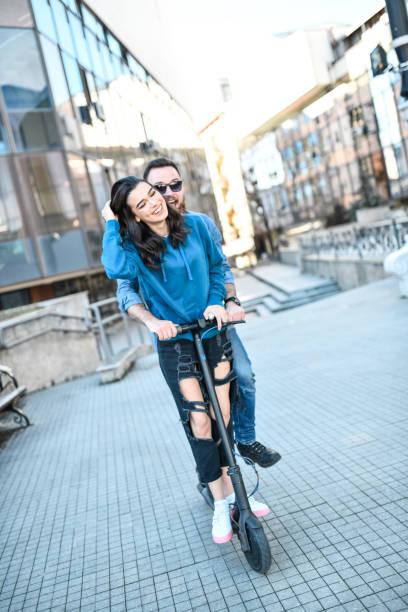 istock Cute Couple Riding On Electric Scooter Outside 1330252694