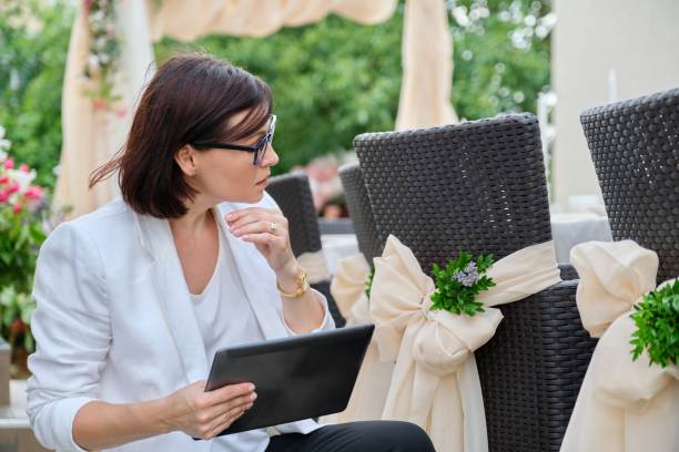 istock Woman professional decorator with digital tablet working outdoors decorating ceremony 1330252895