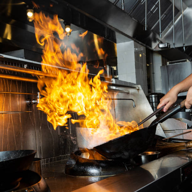 Cooking in the Chinese wok on fire stock photo