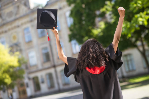 istock Dark-haired graduate feeling happy and excited about graduation 1330256990