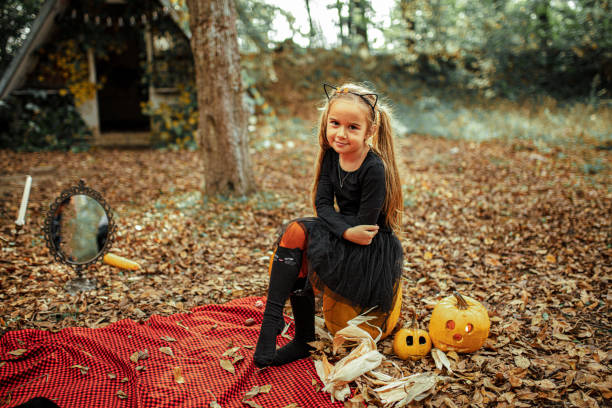 istock Little girl dressed playing as witch at Halloween in the forest 1330257084