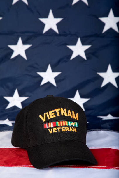 istock Vietnam Veterans cap with American Flag background, vertical 1330257707
