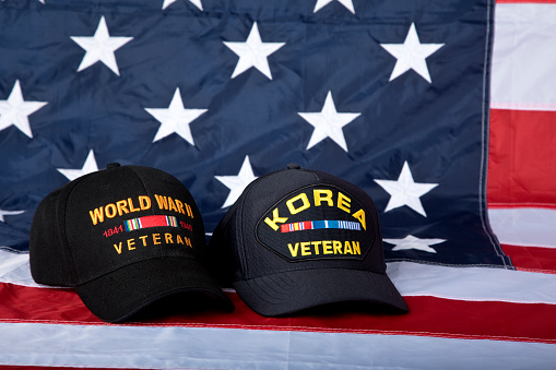 Veterans caps inscribed with text depicting the two wars.