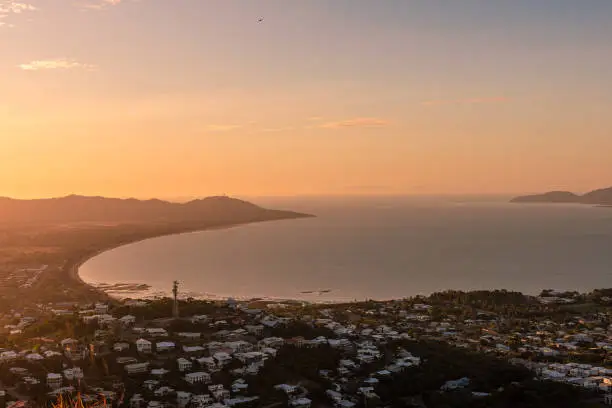 Townsville, Australia - July 12, 2021: The orange cast of the sun setting over the Northern Queensland city of Townsville as seen from the top of Castle Hill.