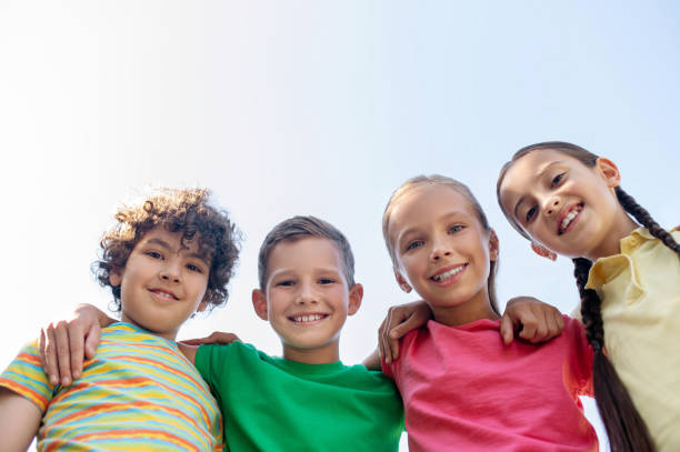 istock Four friends standing hugging each other in fresh air 1330261322