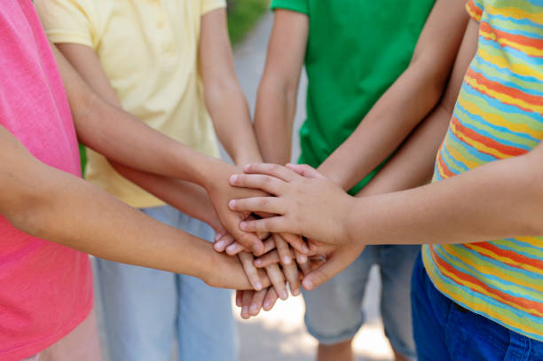 istock Children standing in circle with palms outstretched 1330261334