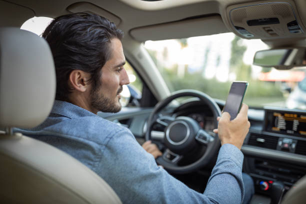 молодой человек в машине - mobile phone seat belt text messaging smiling стоковые фото и изображения