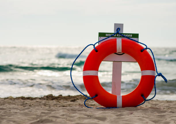 сspecial koła ratunkowego szkarłatnego koloru z linami, zainstalowany na brzegu morza, na plaży w miejscu dla urlopowiczów kąpieli w upalny letni dzień - life jacket buoy sign sky zdjęcia i obrazy z banku zdjęć