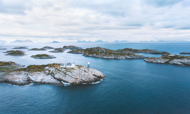 vista aérea faro e isla en el océano en noruega islas lofoten paisaje drone destinos de viaje famosos - lofoten henningsvaer norway village fotografías e imágenes de stock