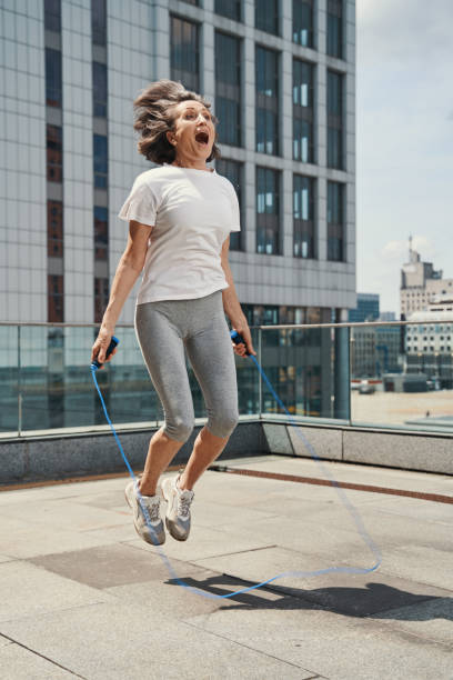 istock Funny aged female jumping on urban roof 1330269091