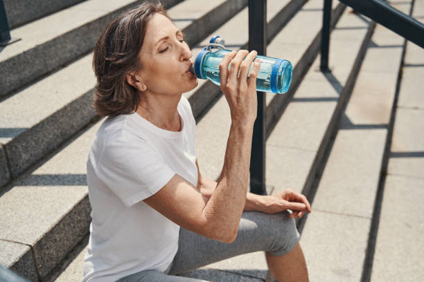 istock Active aged woman quenching thirst on steps 1330269102