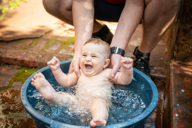 Baby playing in water in summer. stock photo