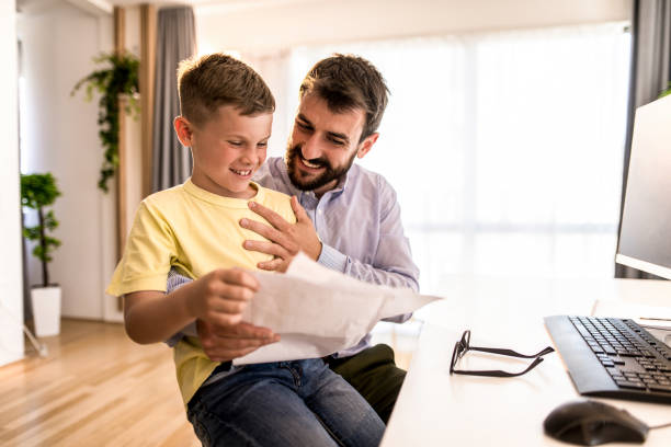 istock Smart kid surprising his father with great exam results from school. 1330276738