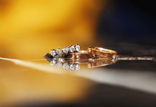 White gold wedding rings tied to ribbons on pillow
