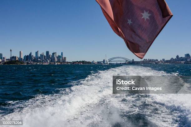 Sydney Landscape From A Boat Red Australian Flog Stock Photo - Download Image Now - Arch Bridge, Architecture, Australia