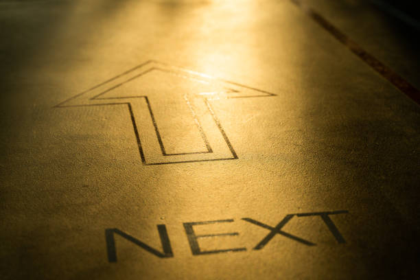 letter next and arrow on the ground for abstract concept, selective focus.