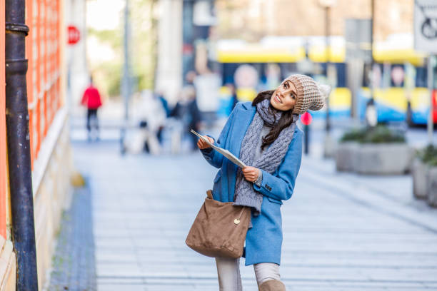 young woman is walking in the city and exploring the sights using a map. - individual event women people autumn imagens e fotografias de stock