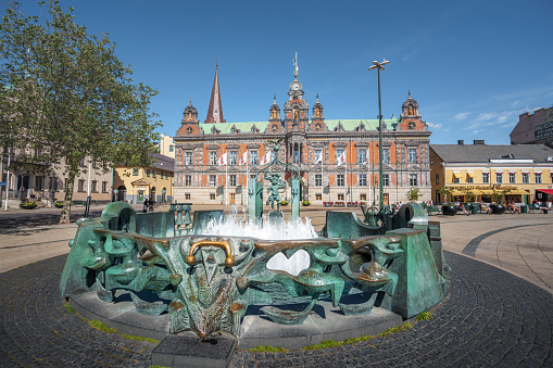 Malmo, Sweden - Jun 23, 2019: The fountain at Stortorget Square with Malmo Town Hall in the background- Malmo, Sweden