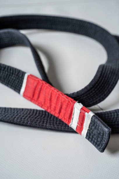 schwarzer brasilianischer jiu jitsu bjj gürtel auf dem boden auf der tatami im fitnessstudio - ju jitsu stock-fotos und bilder