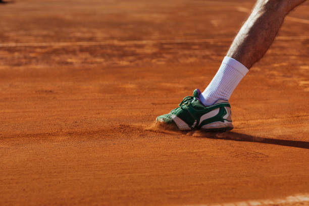 A tennis player sliding on clay An unrecognisable tennis players leg sliding on a clay court clay court stock pictures, royalty-free photos & images