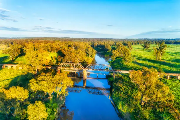 Historic steel railway bridge across Macquarie river in Dubbo rural regional town of Australia - scenic aerial view.