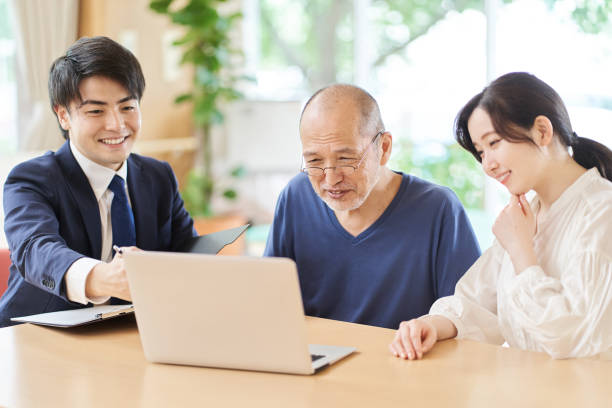 ältere menschen, die erklärungen erhalten, indem sie auf den computerbildschirm schauen - chinese ethnicity ethnic senior adult business stock-fotos und bilder