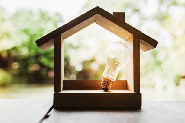 istock Light bulb with wood house on the table, a symbol for construction, Creative light bulb idea, power energy or business idea concept ecology, loan, mortgage, property or home. 1330300230