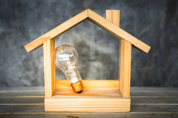 istock Light bulb with wood house on the table, a symbol for construction, Creative light bulb idea, power energy or business idea concept ecology, loan, mortgage, property or home. 1330300272