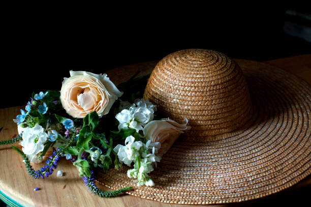 Straw hat with flowers Straw hat with flowers with dramatic lighting cottagecore stock pictures, royalty-free photos & images