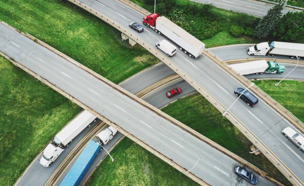 Aerial View of Semi Trucks Aerial view of semi trucks on a highway interchange. (Composite image) trucking stock pictures, royalty-free photos & images
