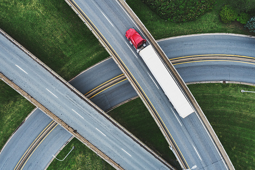 Aerial view of a semi truck on a highway interchange.