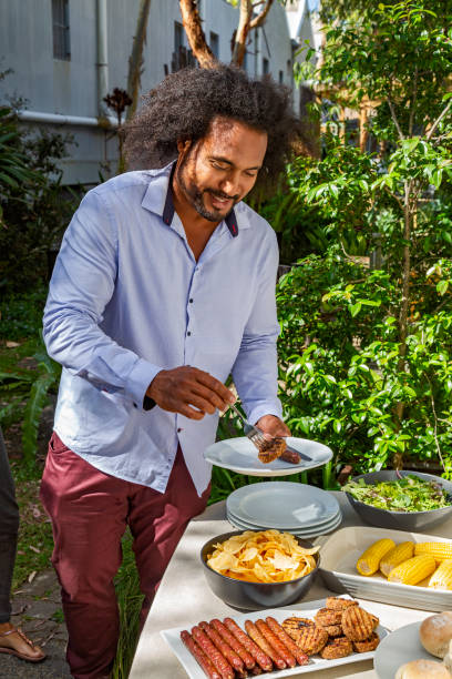 istock Aussie BBQ: young man serves himself food from outdoor patio table 1330309953