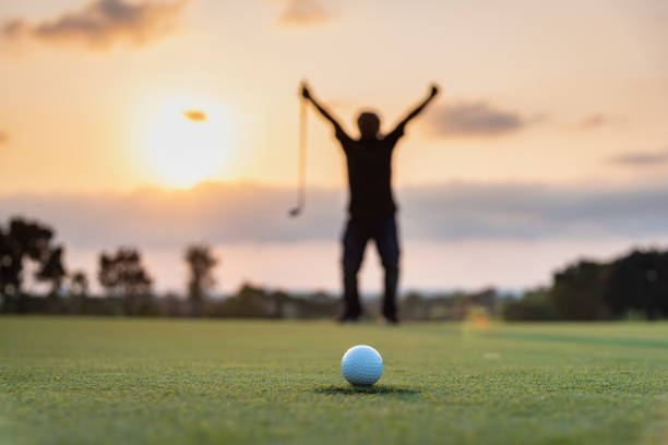 silhouette golfeur montrant le bonheur lors de la victoire dans le jeu, balle de golf blanche sur l’herbe verte du terrain de golf avec fond flou. - golf hobbies happiness cheerful photos et images de collection