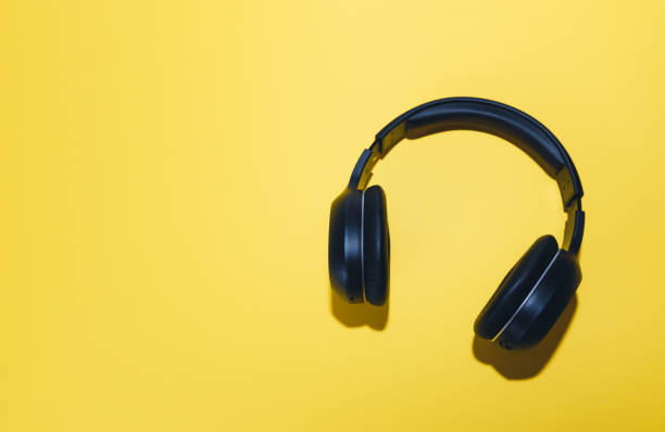 istock Black wireless headphones isolated on a yellow background. 1330315327
