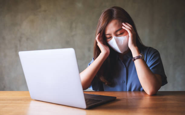 istock Businesswoman with protective face mask get stressed while working on laptop computer in office 1330315891