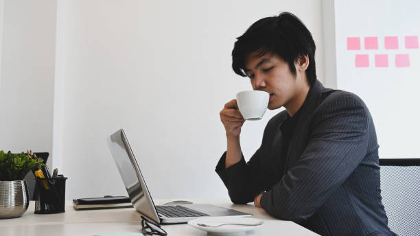 istock Businessman drinking coffee in the morning while sitting at office. 1330319666