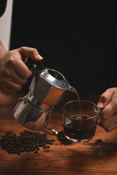 istock Close up man pouring coffee from moka pot into a cup. 1330319686