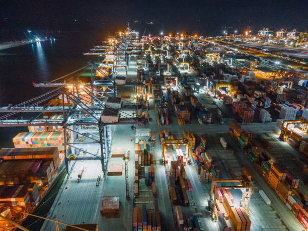 istock Drone point of view of logistics technology business e-commerce import/export and transportation of Container Cargo ship stacking Cargo with working crane bridge in shipyard south east asia 1330324092