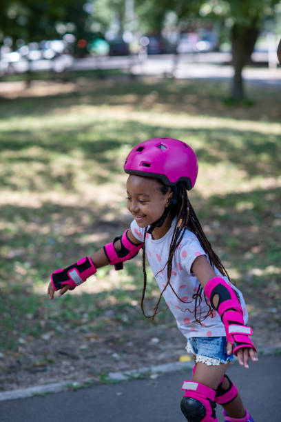 Beautiful young children enjoying the day at a park on rollerblades.